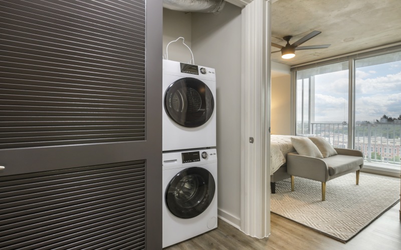 bedroom with large windows and washer & dryer